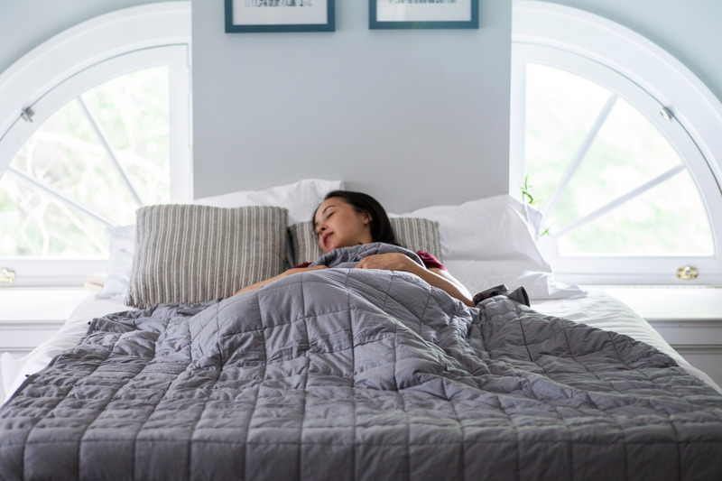 Patient with sleep apnea sleeping under weighted blanket